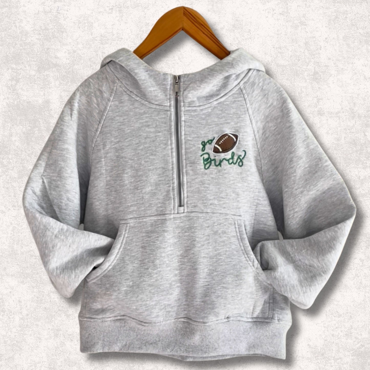 Light grey half zip hoodie with Go Birds embroidered football design on front.