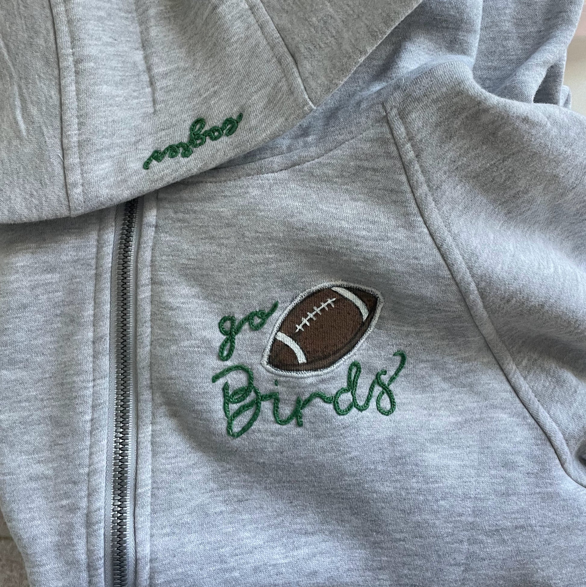 Light grey half zip hoodie with Go Birds embroidered football design on front.